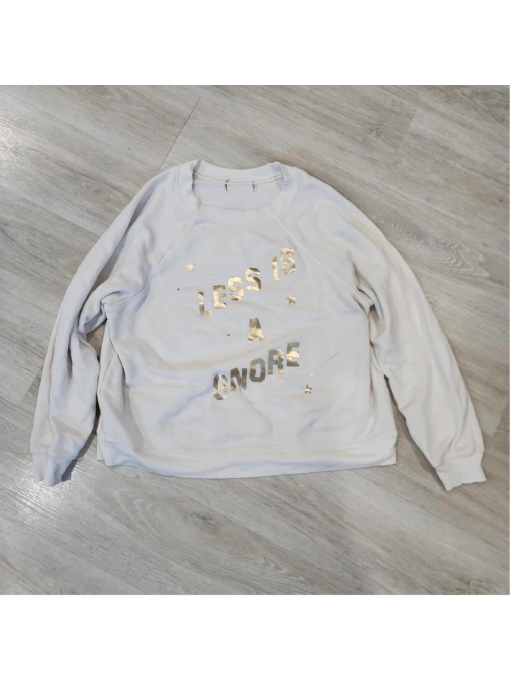 sweatshirt with gold foil text reading 'LESS IS A Snore